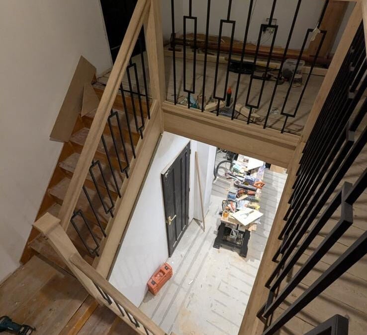 Oak staircase with metal spindles leading down to the hallway