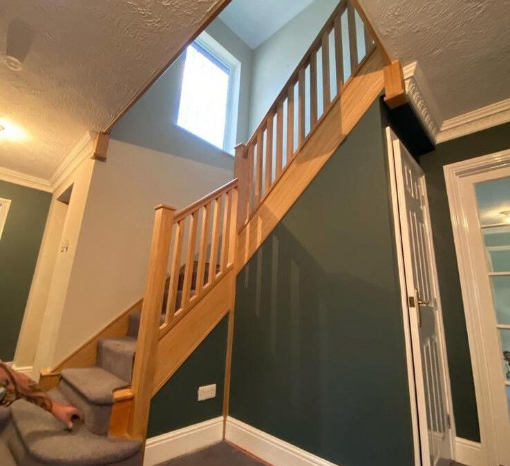 Timber staircase rising to a landing beneath a roof window