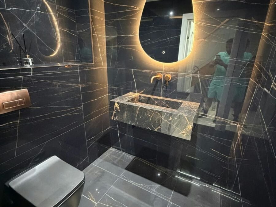 Luxury bathroom installation featuring dark marble effect porcelain wall and floor tiles with white veining