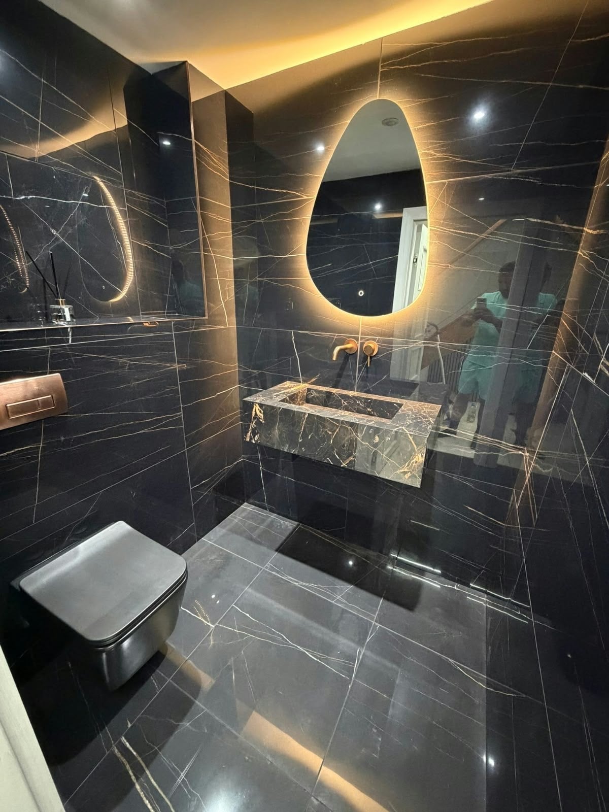 Luxury bathroom installation featuring dark marble effect porcelain wall and floor tiles with white veining