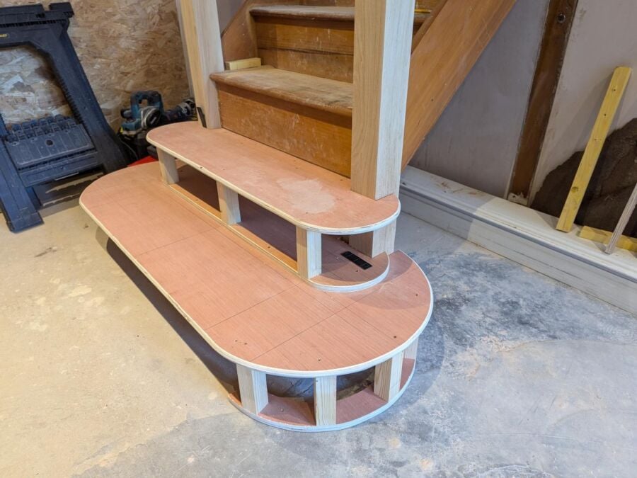 New timber staircase being installed with curved bullnose bottom steps