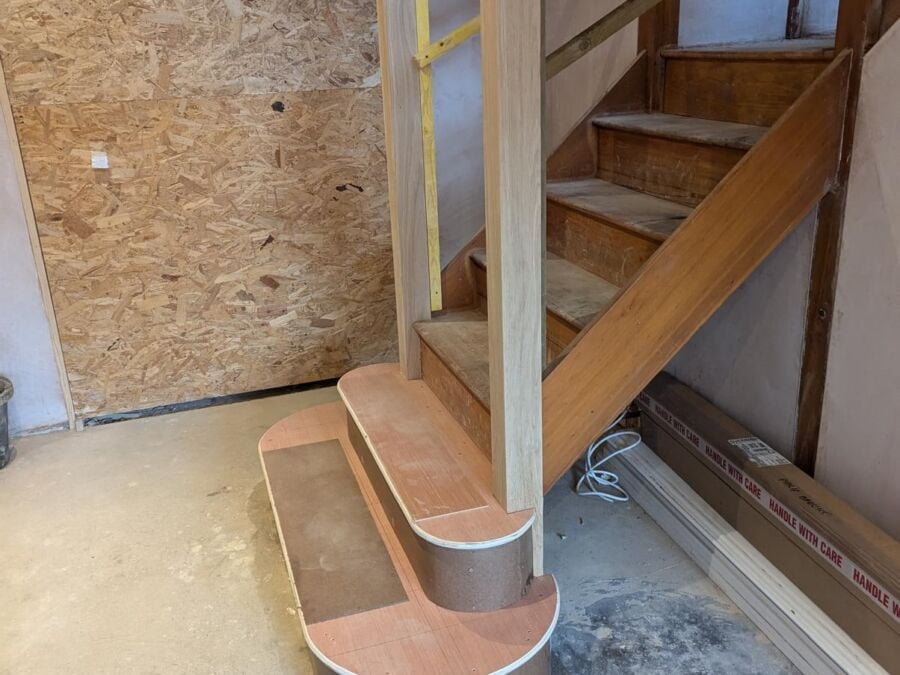 Timber staircase with a curved bottom step and handrail fitted during a renovation
