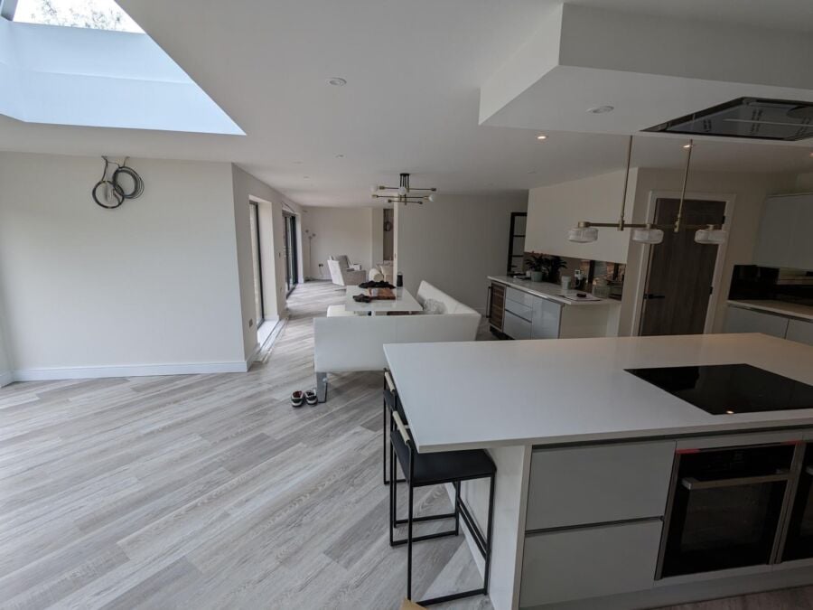 Open plan kitchen extension with island, roof lantern and wood effect flooring