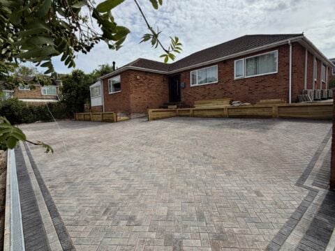 Herringbone block paved driveway with drainage channel and charcoal border at a brick bungalow