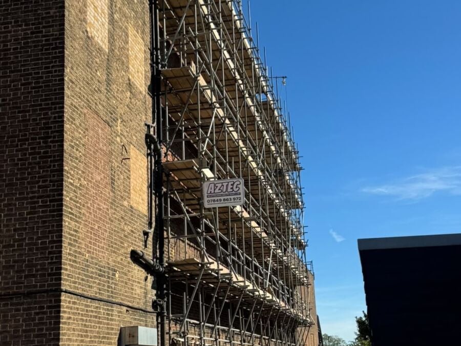Scaffolding erected along the side of a tall brick building