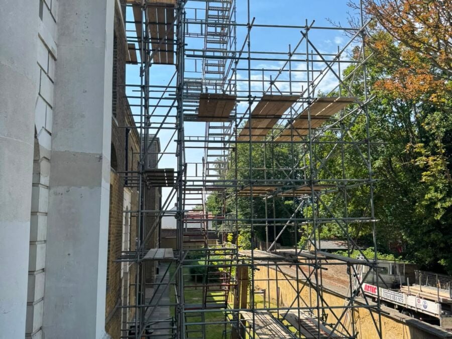 Scaffolding on a period townhouse beside a garden