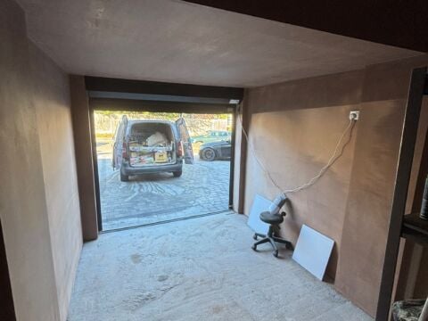 Newly plastered garage conversion with the garage door open