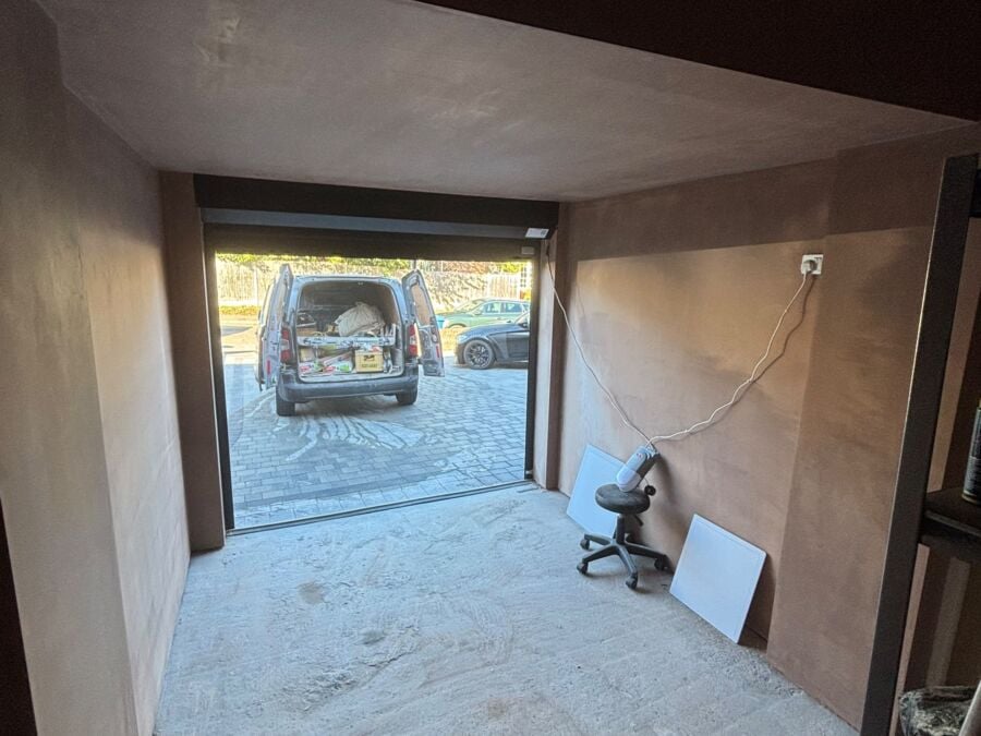 Newly plastered garage conversion with the garage door open