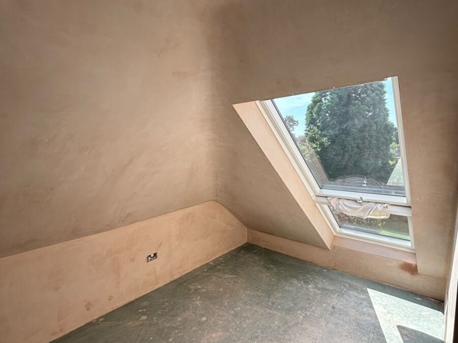 Freshly plastered loft room with a roof window and sloping ceiling