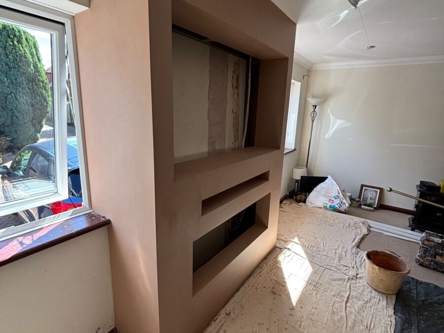 Newly plastered media wall with fire and display recesses in a living room