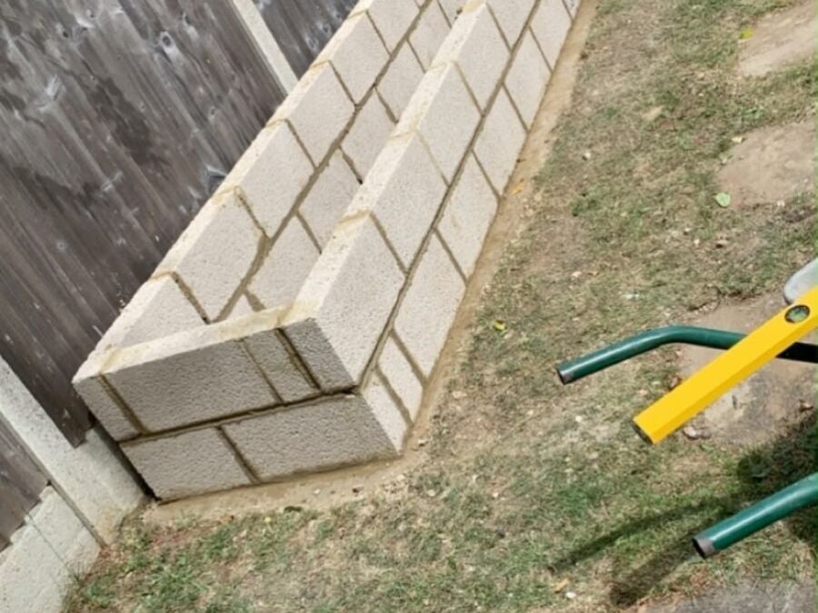 New concrete blockwork raised beds built along a garden fence