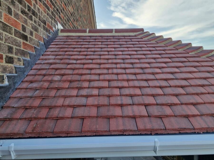 Red plain tile roof with white fascia and guttering