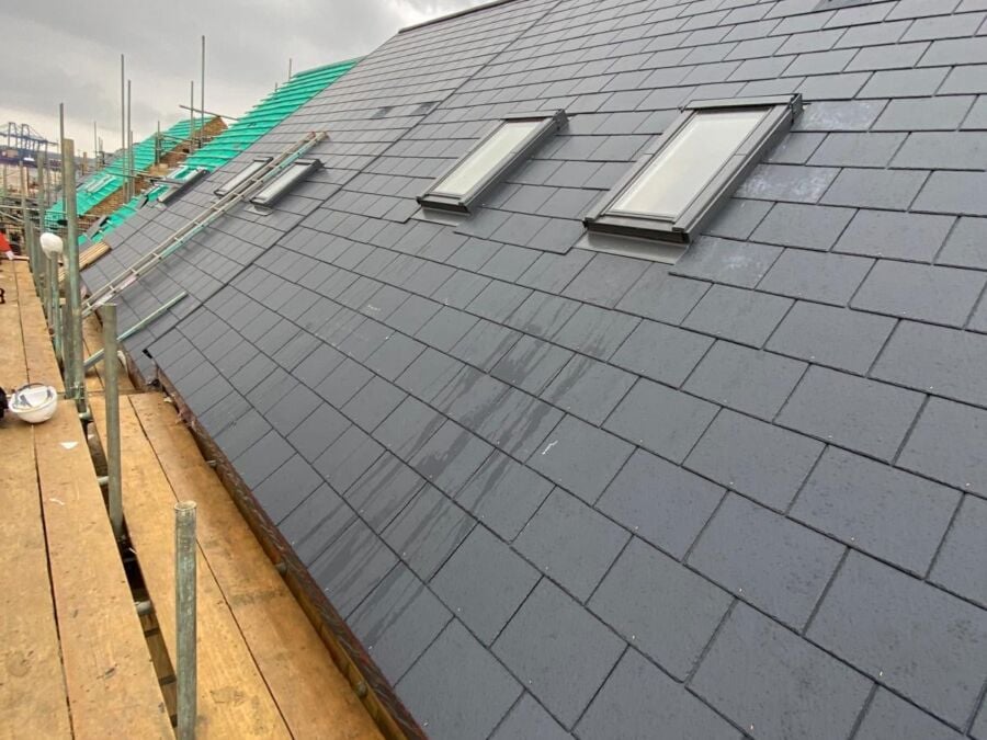 New slate roof with two roof windows, seen from the scaffold